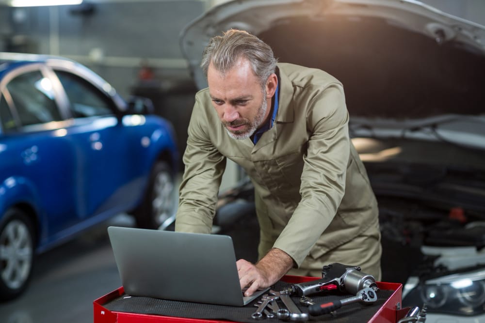 Mechanic using laptop to Identify Engine Detonation Mechanic using laptop to Identify Engine Detonation